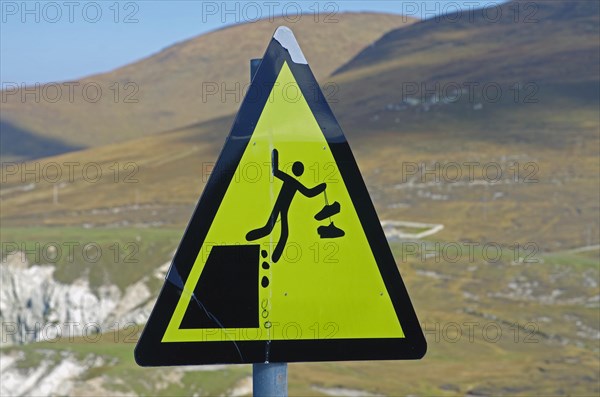 Warning sign with figure falling down