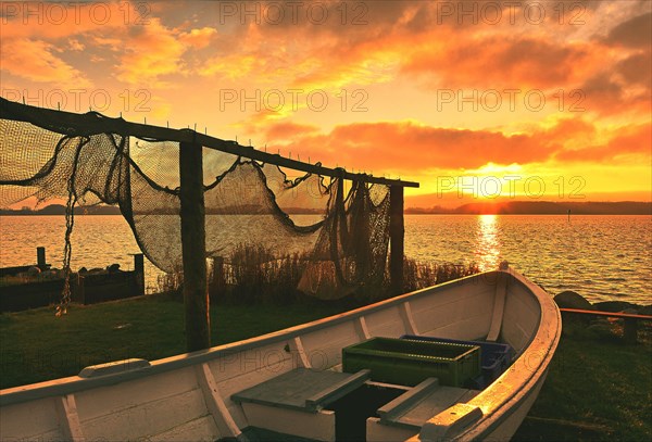 Suspended fishing nets and fishing boat in the sunset