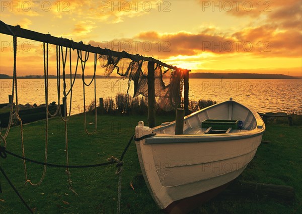 Suspended fishing nets with fishing boat in the sunset