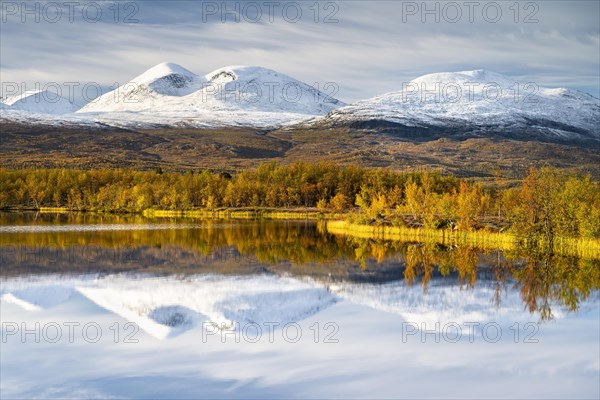 Snowy mountains in Abisko National Park reflected in lake Vuolio Njahkajavri