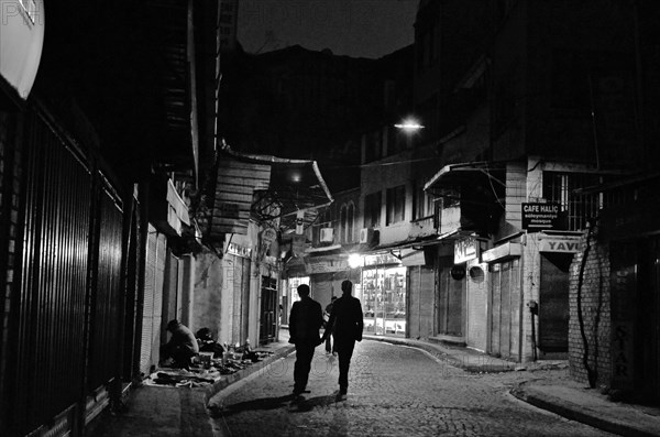 Two men on street in old town Eminoenue at night