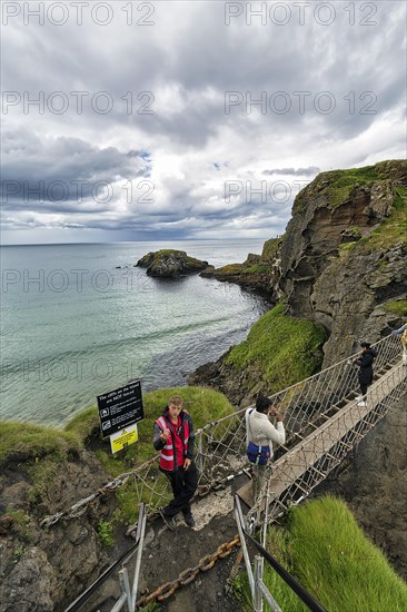 Narrow suspension bridge for pedestrians on rocky coast