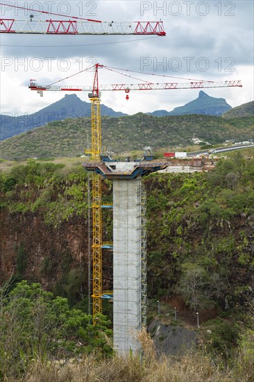 Construction site of bridge with crane across the Grand River of North West near the city of Beau Bassin