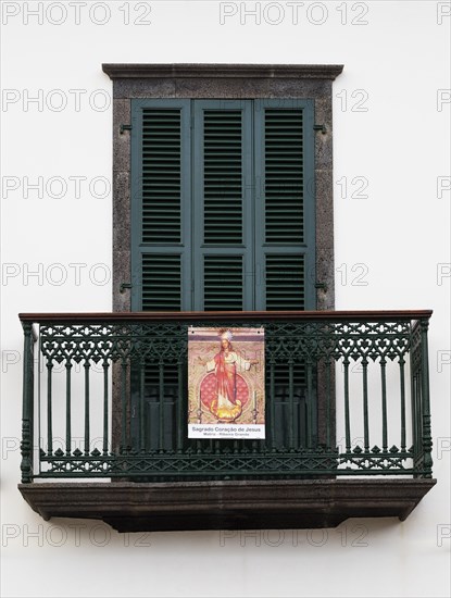 House facade with balcony and image of a saint