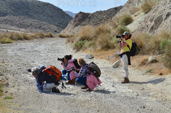 Standing and squatting woman photographers in photography course