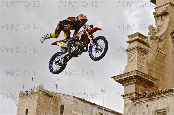 Flying motorbike artist above the rooftops of the old town