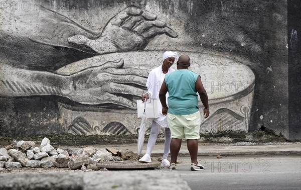 Cubans in front of a large graffiti