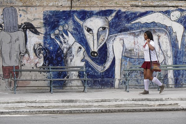 Schoolgirl in front of a large graffiti