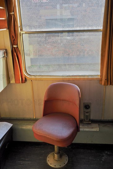 Red single seat inside an old train compartment