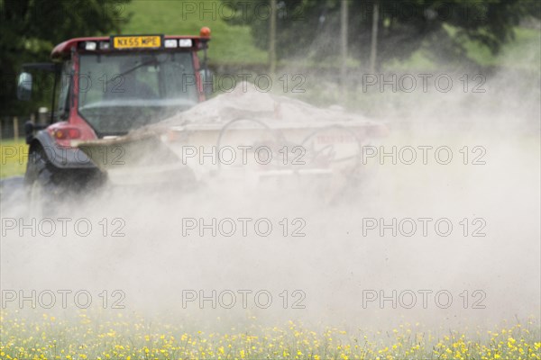 Spreading lime on an Dales dillower meadow to increase the soils fertility. Yorkshire Dales