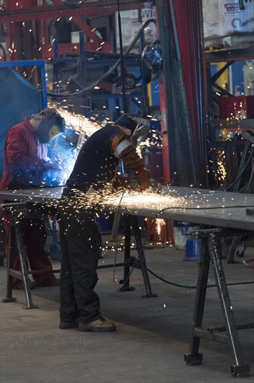 Workers in a factory working with metal on the shop floor