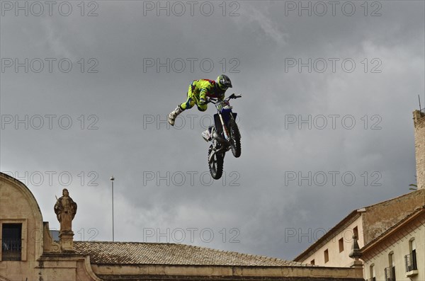 Flying motorbike artist above the rooftops of the old town