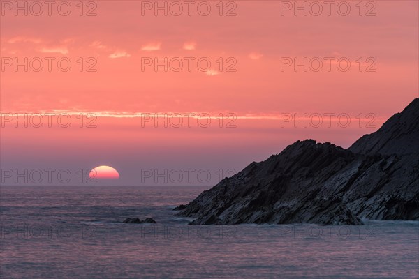 Cliff and ocean at sunset