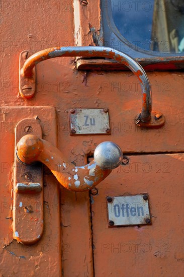Rusty red carriage door of a train from the outside