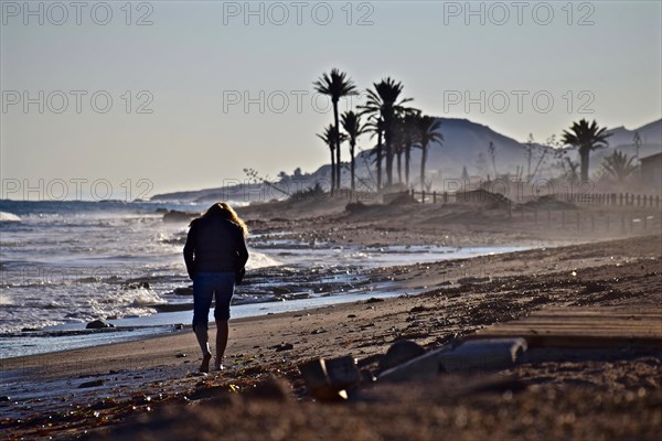 Runner on the beach with palm trees at bay of San Juan de los Terreros