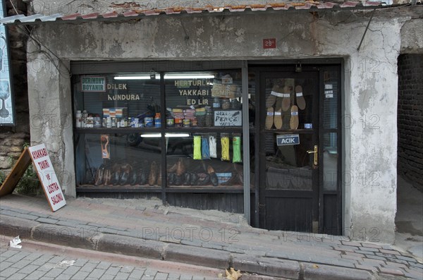 Old cobbler's shop with shop window on street with slope