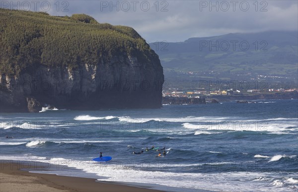 Surfers on the sandy beach Praia de Santa Barbara near Ribeira Grande