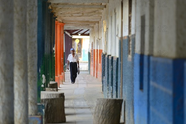Old man in the arcades of a colonial house