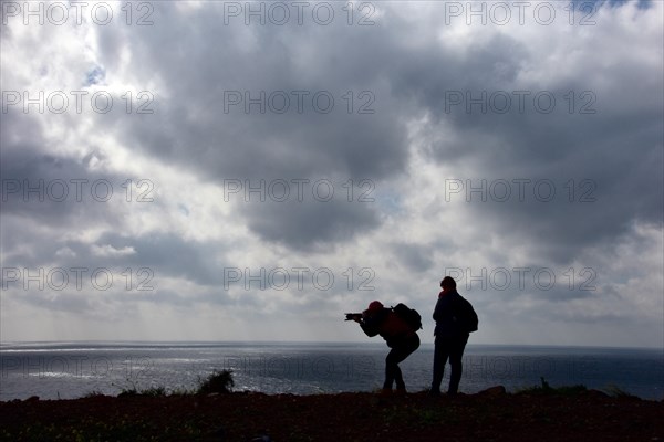 Women photographers with camera at the cloudy sea