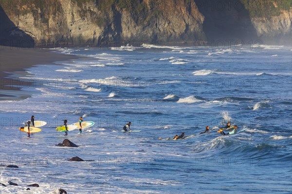 Surfers on the sandy beach Praia de Santa Barbara near Ribeira Grande