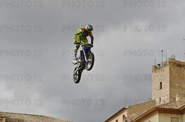 Flying motorbike artist above the rooftops of the old town