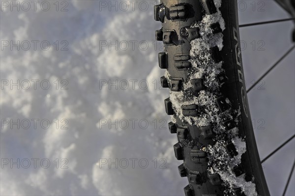 Close-up of bicycle tyre with tread in snow