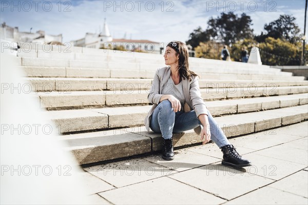 Young woman sitting on the stairs in Faro