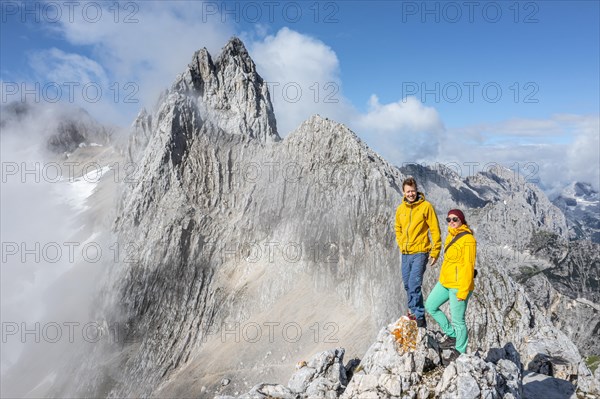 Two hikers in front of alpine panorama