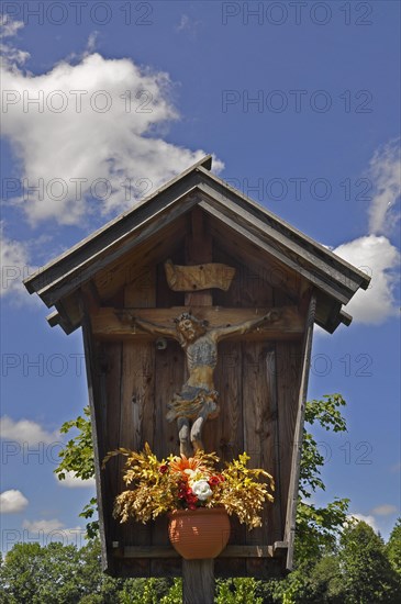 Wooden shrine with crucifix and flowerpot