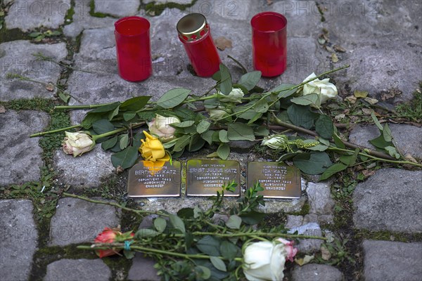 Roses and mourning candles at three memorial stones