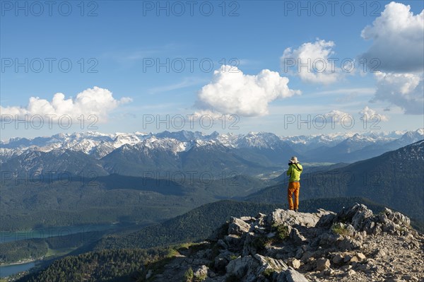Hiker taking photos at the summit of Heimgarten