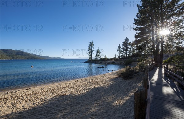 Wooden walkway on sandy beach with sun star