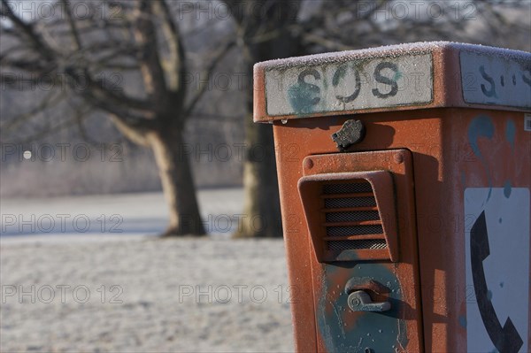 Red SOS emergency pillar with hoarfrost in winter