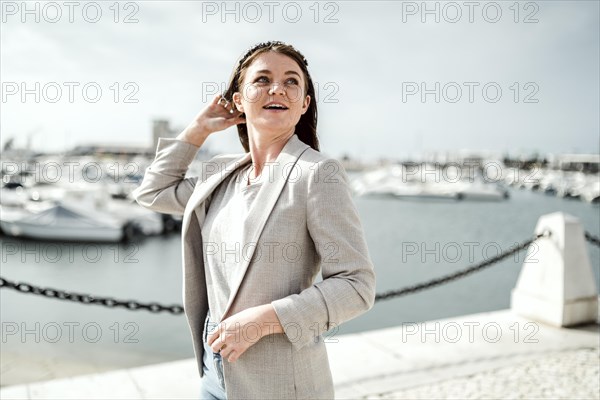 Portrait of young woman walking by marina in Faro