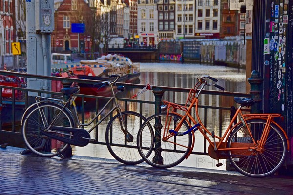 Dutch bicycles on bridge railings of a canal in Amsterdam