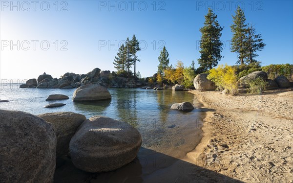 Sand beach and round stones in the water