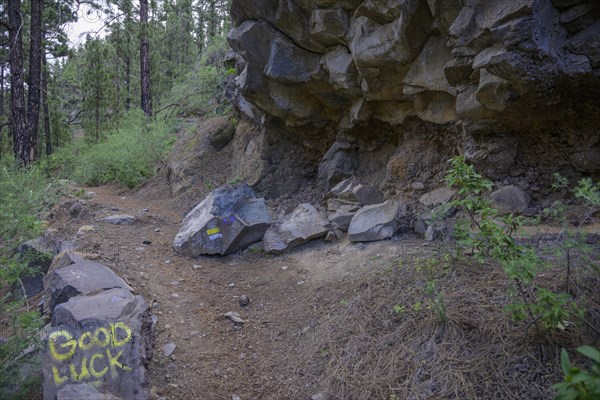 Rockfall hazard and ironic inscription on rocks good luck