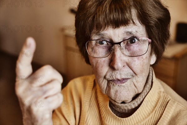 Angry senior citizen threatens with her raised index finger