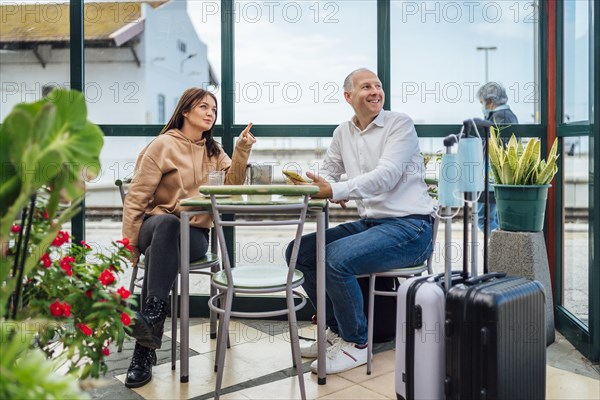 A couple of travelers drinking coffee and checking something on the phone