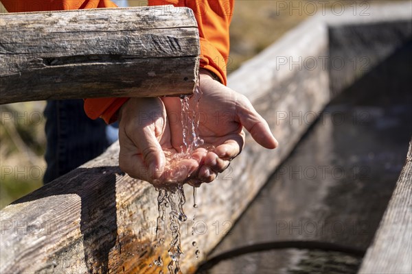 Hiker draws water from a well