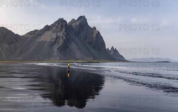 Young woman with rain jacket walking on beach