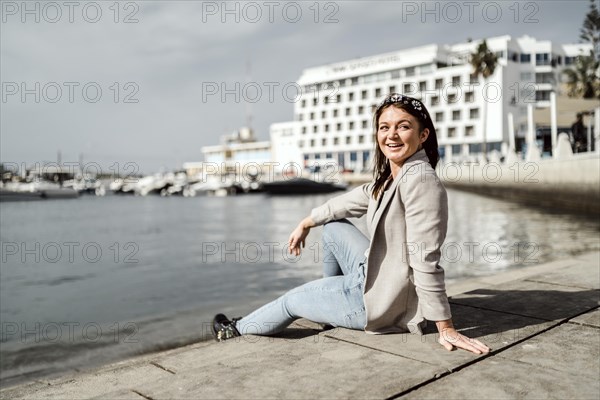 Young woman sitting by the marina in Faro