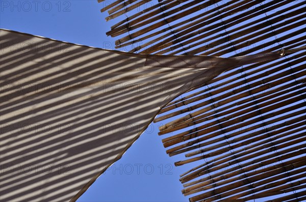 Sun sail meets sun straw mat in the blue sky