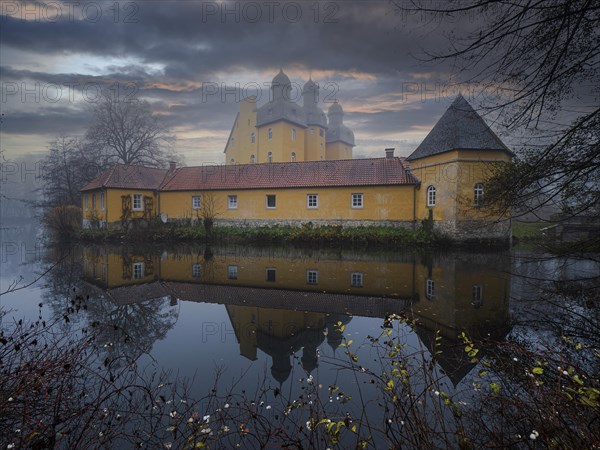 Schloss-Holte moated castle in autumn as fog rolls in