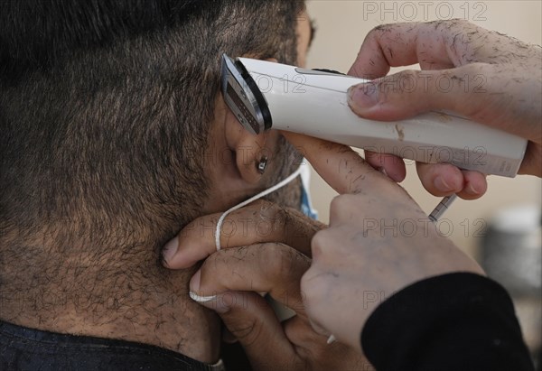 Hair clippers around the ear with mouth guard