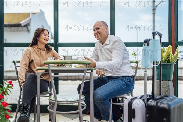 A couple of travelers drinking coffee and checking something on the phone