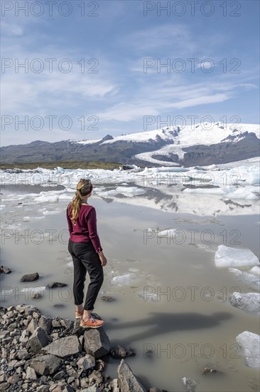 Woman standing in front of Fjallsarlon ice lagoon