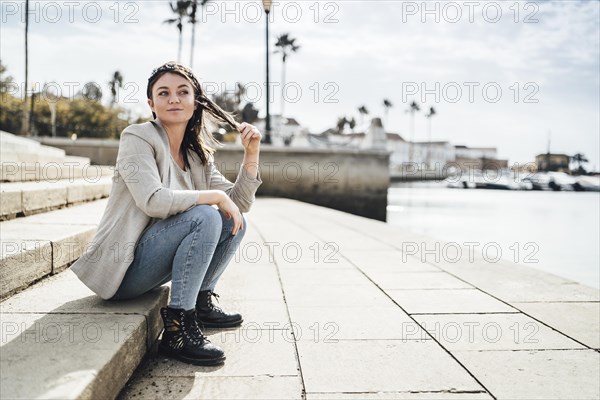 Young woman sitting by the marina in Faro
