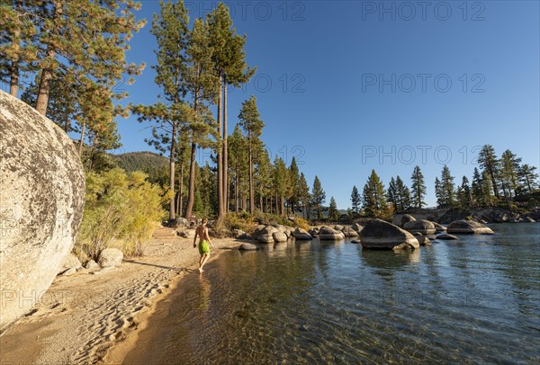 Young man in swimming trunks on sandy beach