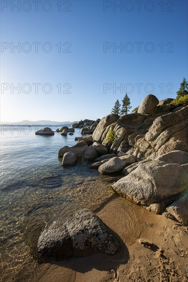 Sand beach and round stones in the water